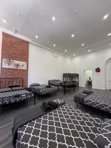 a room with four beds and a brick wall at 31 Street Broadway Hotel in New York