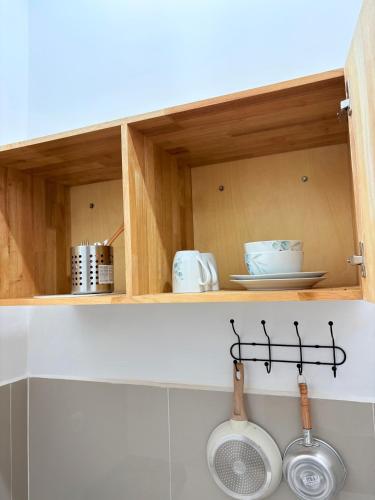 a kitchen with wooden cabinets with utensils in it at De Cabin Situjuah in Situjuhbatul