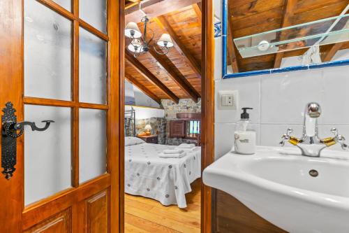 a bathroom with a sink and a table at La Casina Del Fornu in Pravia