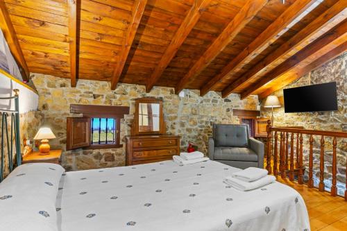 a bedroom with a bed and a tv in a room at La Casina Del Fornu in Pravia