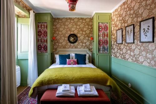 a bedroom with a bed with two shoes on a bench at Rosegarden Essence Sintra - by Unlock Hotels in Sintra