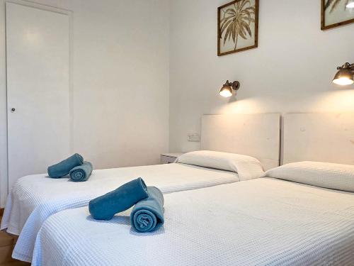 two beds in a room with blue pillows on them at Seafront L'Estartit Roof in L'Estartit