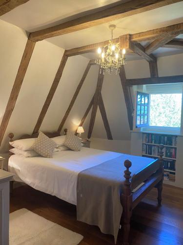 a bedroom with a large bed with a chandelier at La Maison du Gardien in La Celle-sous-Gouzon