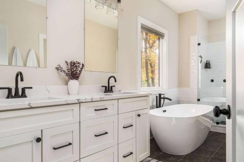 a white bathroom with a tub and a sink at Valley View in Basye