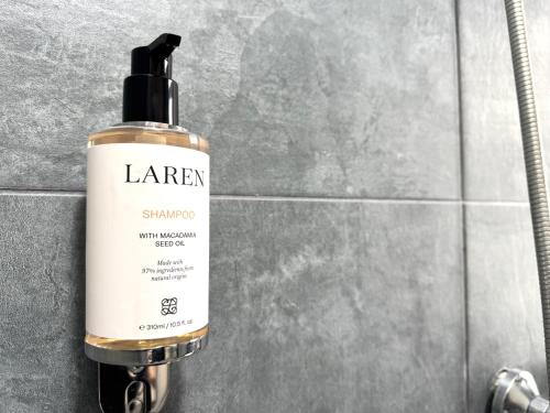 a bottle of larr shampoo sitting on a bathroom counter at E - Central Room Five in Skopje