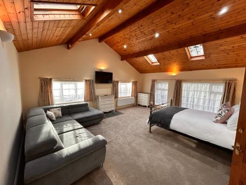 a large bedroom with a bed and a couch at Deandale Stays in Handforth