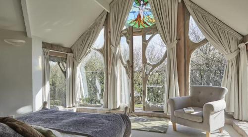 a bedroom with a bed and a chair and a window at Glastonbury tranquility in Glastonbury