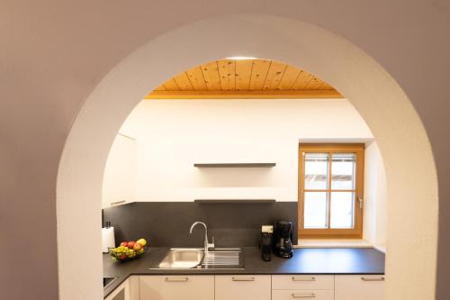 an archway in a kitchen with a sink at Wolkanhof Vineyard Apartments in Appiano sulla Strada del Vino