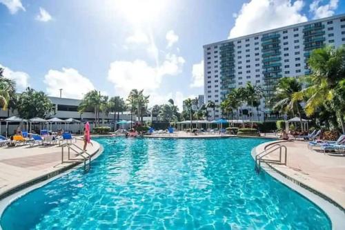 a swimming pool in a resort with chairs and a building at Introdused by Ocean Reserve free parking STR-02559 in Sunny Isles Beach