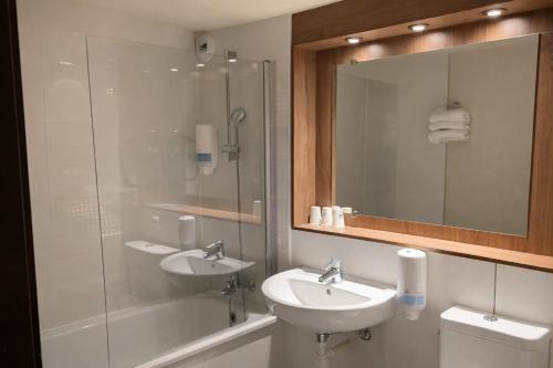 a bathroom with two sinks and a glass shower at Kyriad Montargis Amilly in Amilly