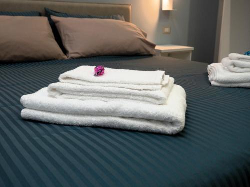 a pile of towels sitting on top of a bed at L'Oasi del Poeta in Crotone