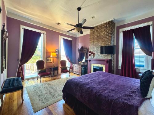 a bedroom with a purple bed and a fireplace at The Dragonfly Tremé-Historic Guesthouse-Near French Quarter in New Orleans