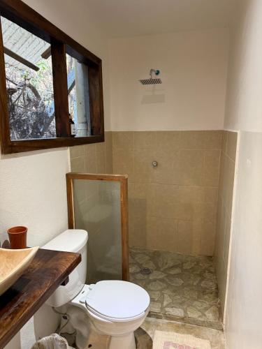a bathroom with a toilet and a sink at Green oasis across from the main street in Mazunte