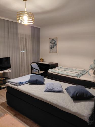 two beds in a room with a piano in the background at Rohrbacher Hof in Berg bei Rohrbach
