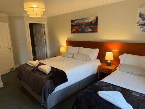 a hotel room with two beds and two lamps at 36 Flesk River Apartment in Killarney