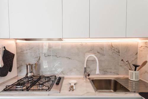 a kitchen counter with a sink and a stove at Al Melograno in Aquilinia