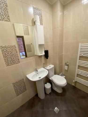 a white bathroom with a toilet and a sink at Къща за гости Гергана in Ribarica