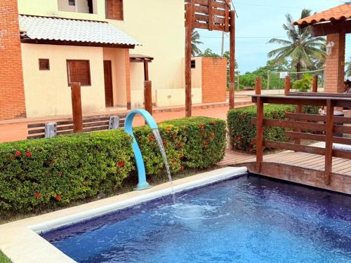a pool with a water fountain in a yard at Flat Studio Casal - Praia da Lagoa do P a u - Coruripe in Coruripe