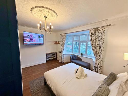 a bedroom with a bed and a tv on a wall at Private All-Weather Hot Tub Apartment, Free Parking, 1 Mile to City Centre, Cafés & Dining Nearby in Jesmond