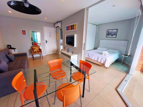 a living room with a table and orange chairs at Book Santos Mar à Vista no Unique Residence 1810 in Santos