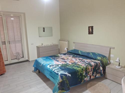 a bedroom with a bed with a colorful blanket at B&B I Gigli in Brusciano