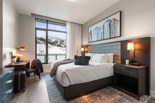 a hotel room with a bed and a desk and a window at Abode at Deer Valley East in Park City