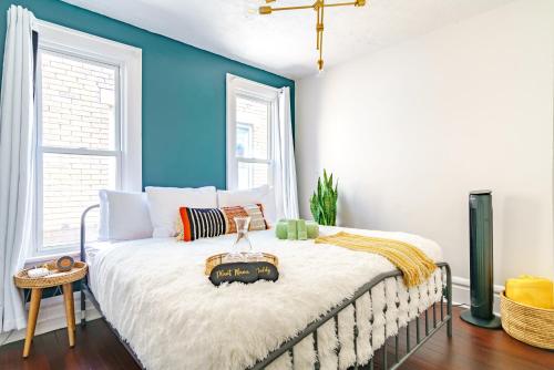 a bedroom with a bed with a blue wall at Jungle House Columbus Short North Downtown Free Parking - Steps to Convention Center & Nationwide Arena - 2BR Luxury Home - Sleeps 8 - Over 5,800 Five Star Stays in Columbus