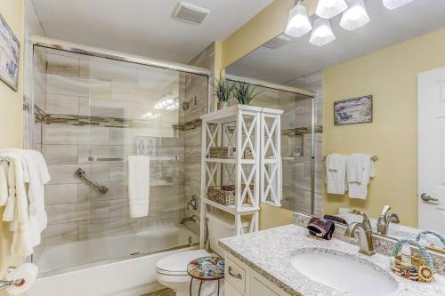 a bathroom with a shower and a sink and a toilet at Oceanfront 5th-floor condo with balcony, gorgeous views & pool access in Fernandina Beach