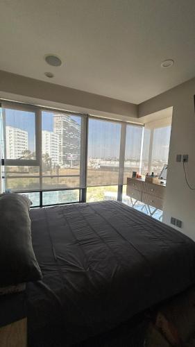 a bedroom with a large bed with a large window at Modern apartment in Angelopolis - 2 bedrooms in Tlazcalancingo