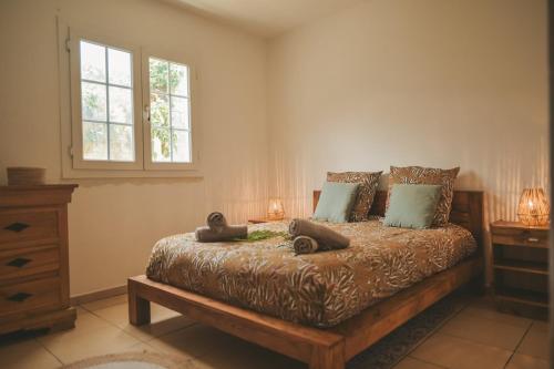 a bedroom with a bed with two pillows and a window at L'Escapade des Hauts location saisonnière avec jacuzzi in Le Tampon