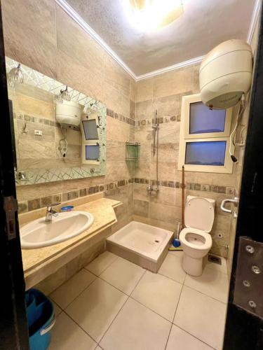 a bathroom with a toilet and a sink and a tub at Prime Plaza Porto Towers Stay Hotel VIP in Ain Sokhna
