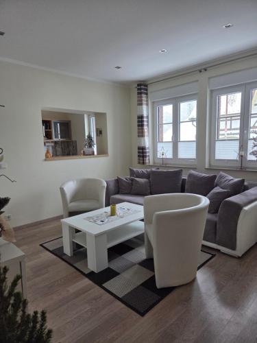 a living room with a couch and a table and chairs at Harznester Schierke in Schierke
