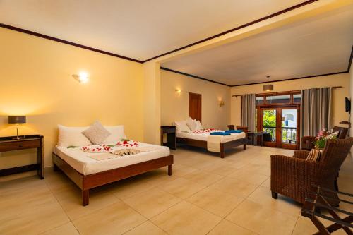 a hotel room with two beds and a desk at Sun Properties and Resort Hotel in Beau Vallon
