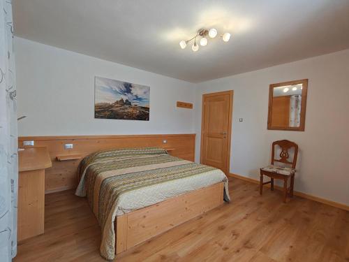 a bedroom with a bed and a wooden floor at Appartamento panoramico 1 in Dosoledo