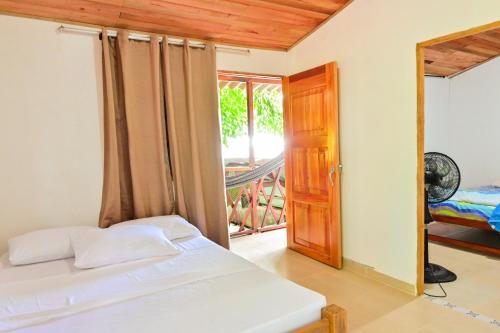 a bedroom with a bed and a door to a balcony at El Ranchito de Turbo in Turbo