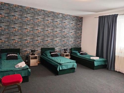 a room with two green couches and a brick wall at Villa Varzob lll in Warsaw