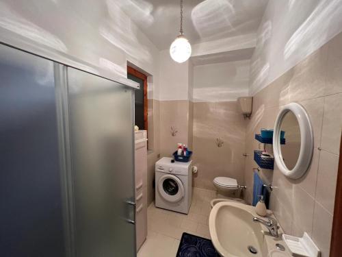 a bathroom with a sink and a washing machine at Casa Primula - Family Country House immersa nel verde a 5 min dal Mare in Ricadi