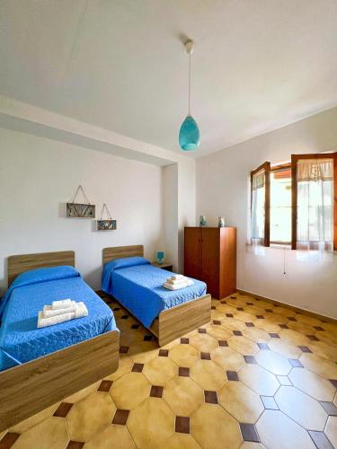 a bedroom with two twin beds and a floor at Casa Primula - Family Country House immersa nel verde a 5 min dal Mare in Ricadi