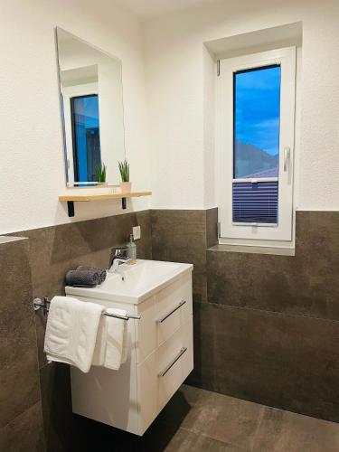a bathroom with a white sink and a window at Berghoamat Nauders in Nauders