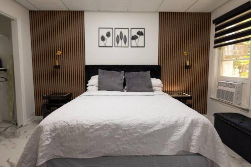 a bedroom with a large white bed with two tables at Studio•Basement• Back Entry Basement•1BRD•Ste B in Lawrenceville