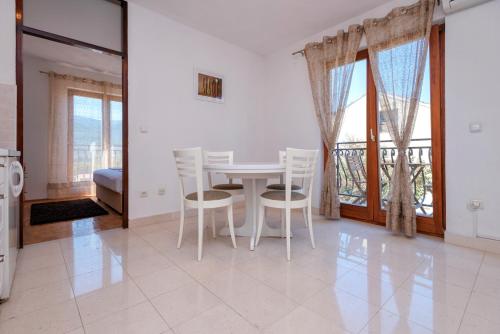 biała jadalnia ze stołem i krzesłami w obiekcie MI Apartment w mieście Stari Grad