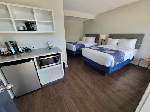 a hotel room with two beds and a microwave at Brio Beach Inn in Traverse City