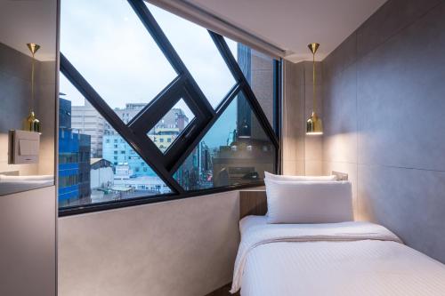 a bedroom with a bed and a large window at Hotel Relax 5 in Taipei