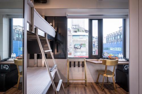 a loft bed in a room with a desk and a desk at Hotel Relax 5 in Taipei