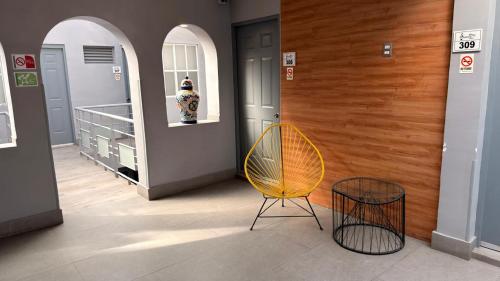 a hallway with a yellow chair and two baskets at Hotel Sonora, Centro Histórico in Mexico City
