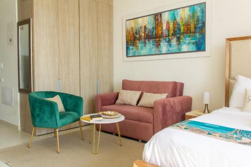a bedroom with a bed and a couch and a chair at Vela Mare Suite in Santa Marta