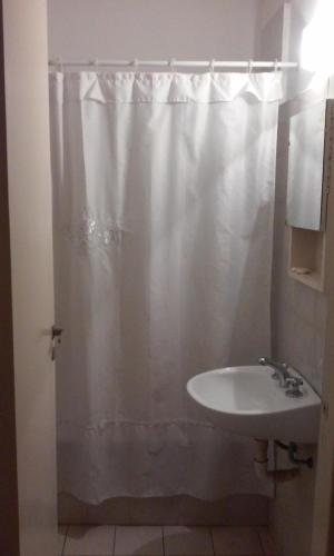 a bathroom with a white shower curtain and a sink at Hotel Urca in Mar del Plata