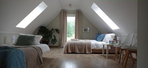 a attic room with two beds and a table at Domek w okolicy Karpacza in Marczyce