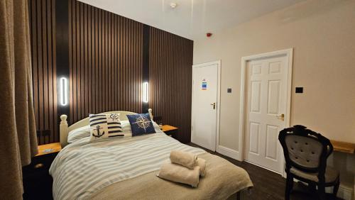 a bedroom with a bed with a chair and two lights at Amble Harbour retreats in Amble