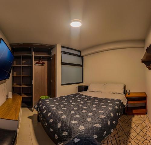 a bedroom with a bed and a flat screen tv at Apartment E18 UPAO 2nd Floor in Trujillo